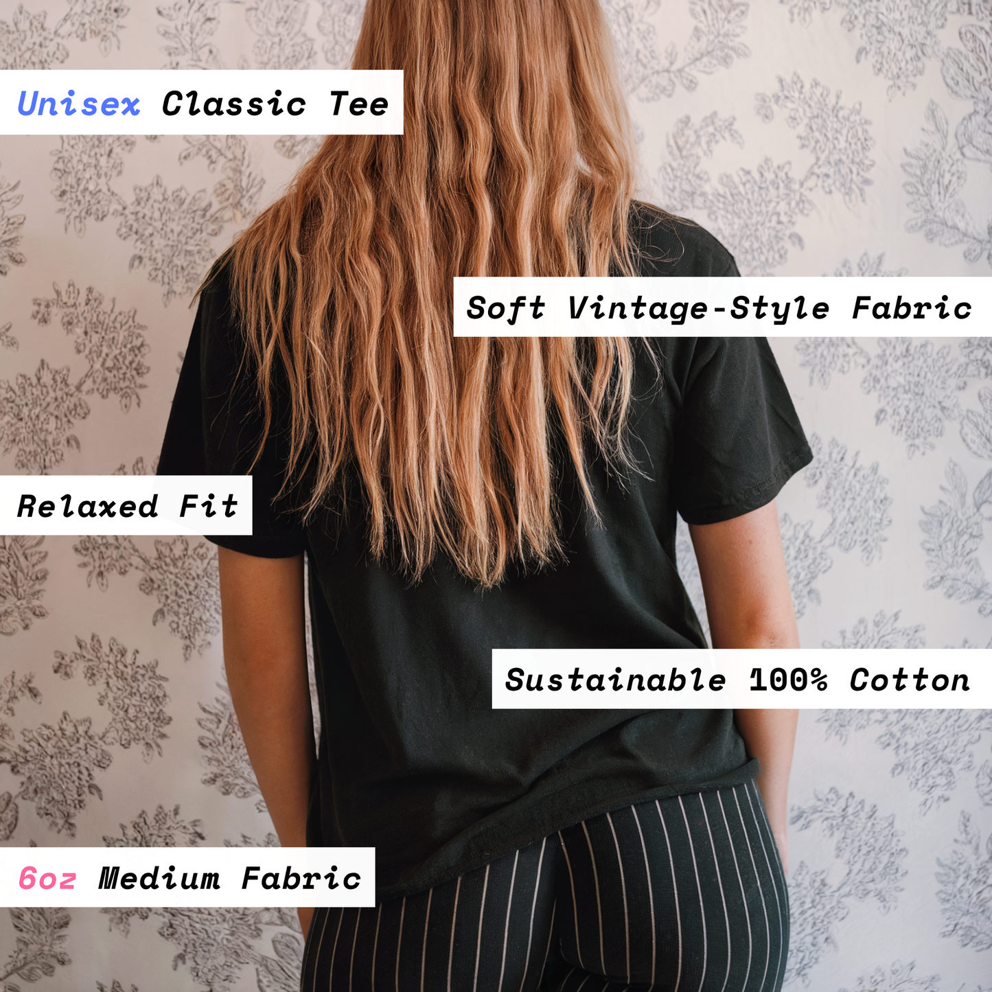 Person wearing a black unisex classic tee with text describing fabric and fit details on a floral background